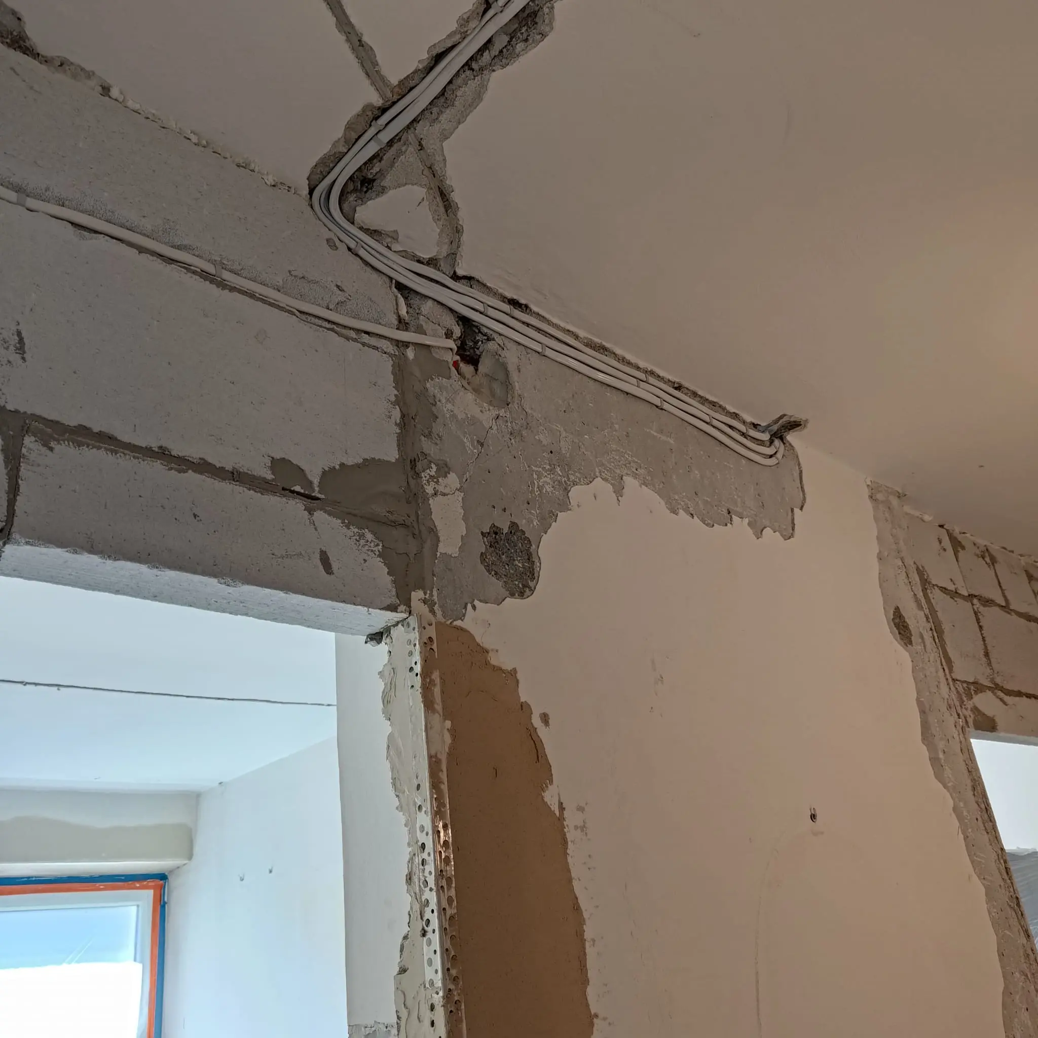 Odkryte przewody elektryczne prowadzone w ścianie i suficie