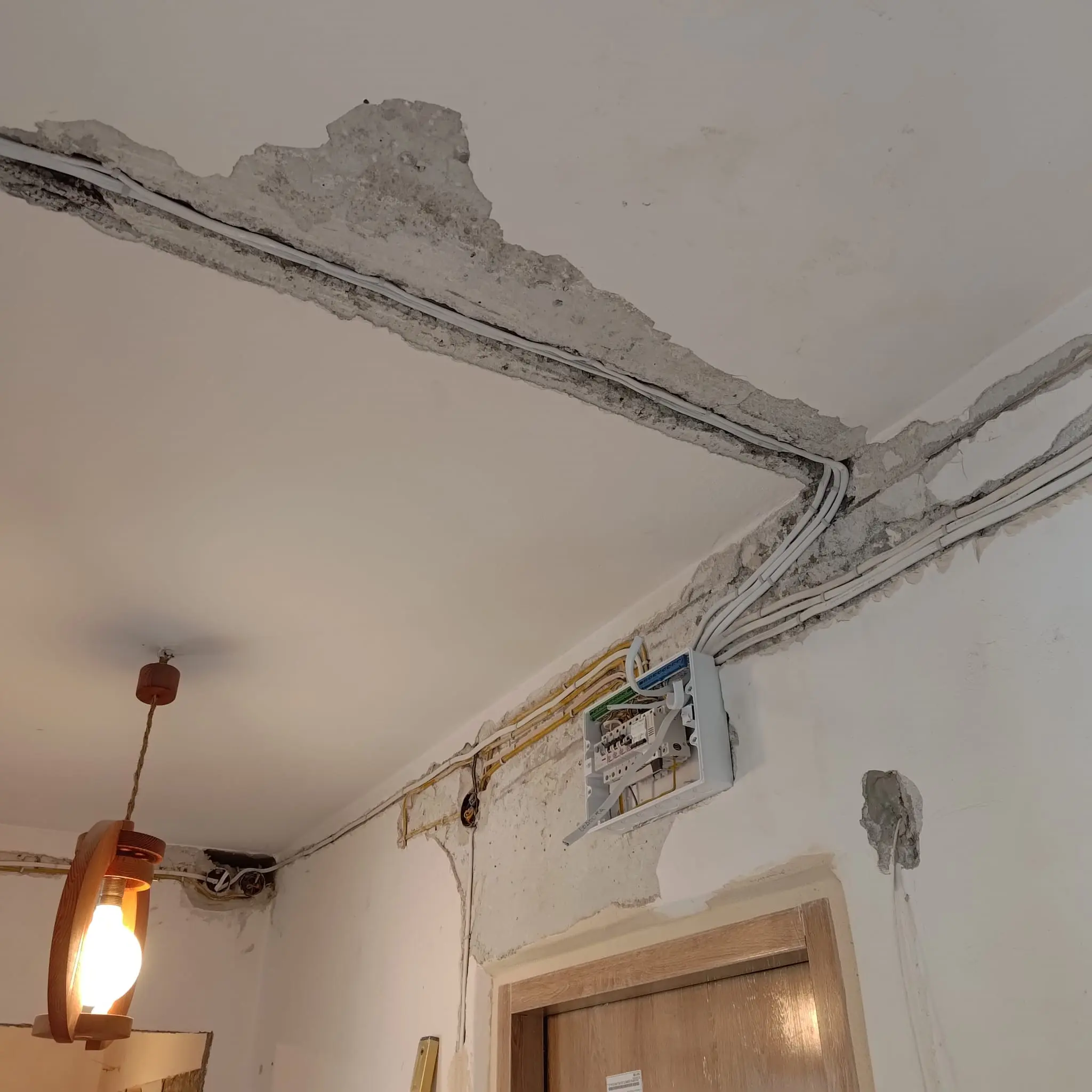 Przewody instalacji elektrycznej prowadzone przy suficie podczas remontu